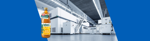 Picture of a plastic production machine. In the foreground, a Hohes C bottle produced by this machine.